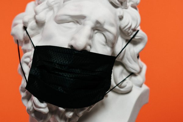 White ceramic sculpture with black face mask