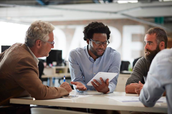 Businessman presenting to co-workers with tablet