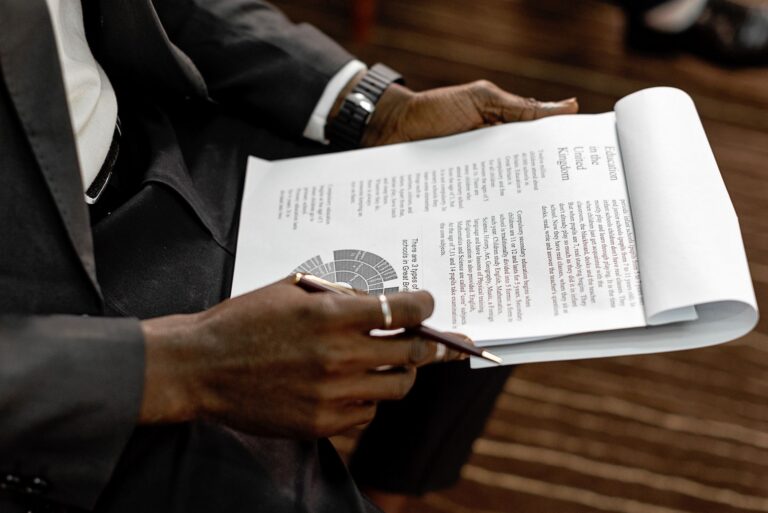 Professional reviewing financial documents and charts in a binder for a government cost proposal
